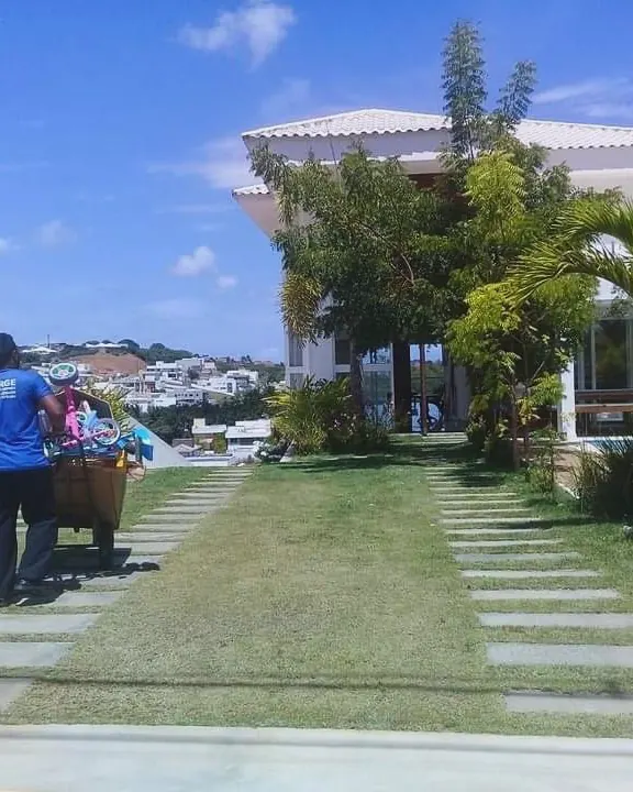 Funcionário com carrinho de carga no jardim de uma casa
